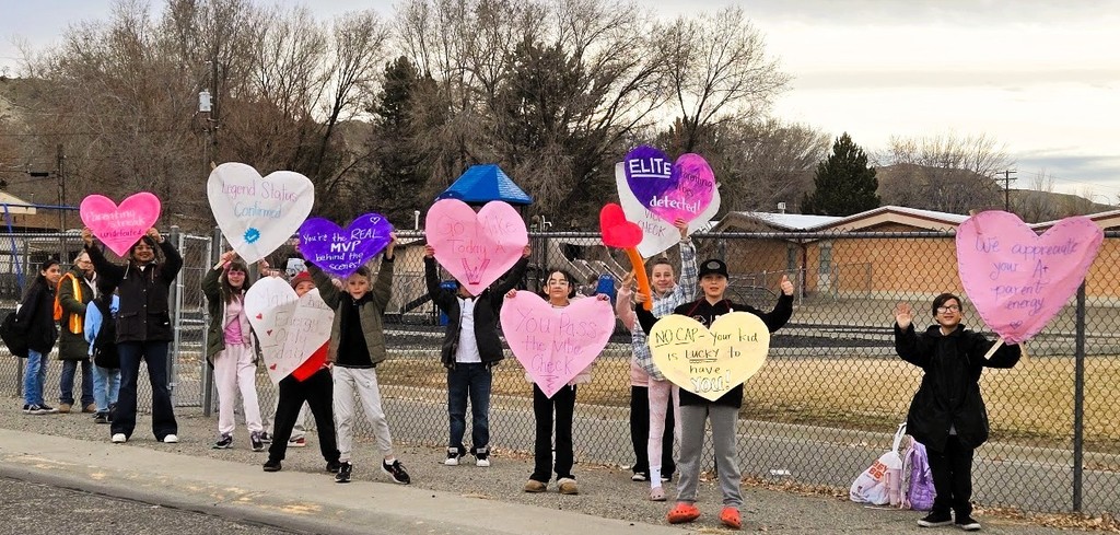 A group of students from the Save Promise Club holding hearts with inspirational messages for parents.
