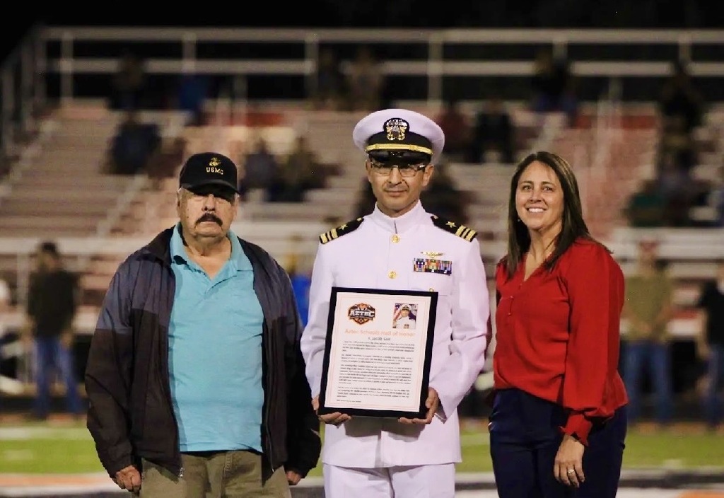 Photos from Friday night's Aztec Schools Hall of Honor induction ceremony, featuring 2026 inductees Jesse Russell, Bill Francis, and J. Jacob Saiz being recognized on the football field. Additional photos show plaques honoring each inductee. Photos by Landry Bentley.