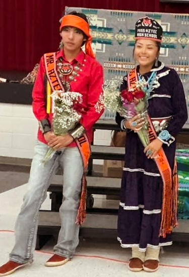 Photos from the annual Miss and Mr. Aztec High School Pageant. Students showcase traditional Navajo clothing, cultural regalia, and pageant sashes. The photos include a Miss Aztec High School titleholder, a student speaking into a microphone, a student holding traditional wooden sticks, and two pageant participants posing with bouquets of flowers.