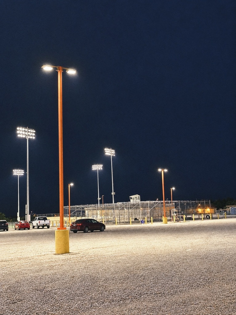 New stadium lights illuminate the parking area and facilities at Fred Cook Memorial Stadium at night, showcasing improvements made through Aztec Municipal Schools’ 2 Mill Levy funds.