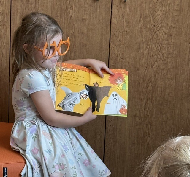 Kindergarten student reads a book