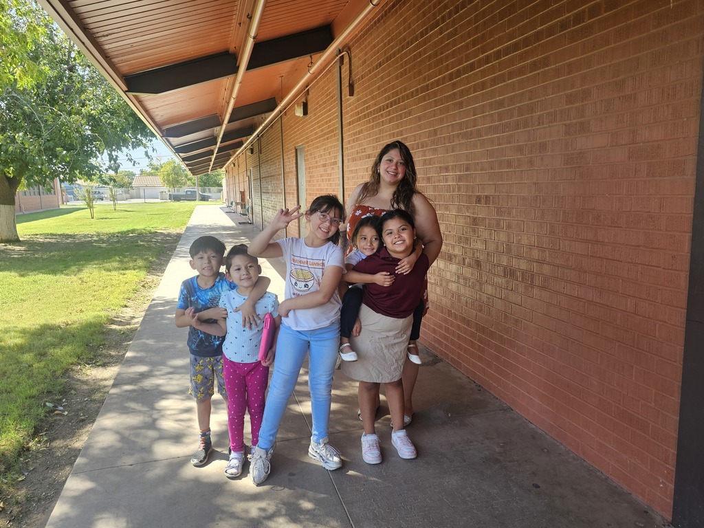 Mother and 5 children smiling during their parent teacher conferences meeting at school