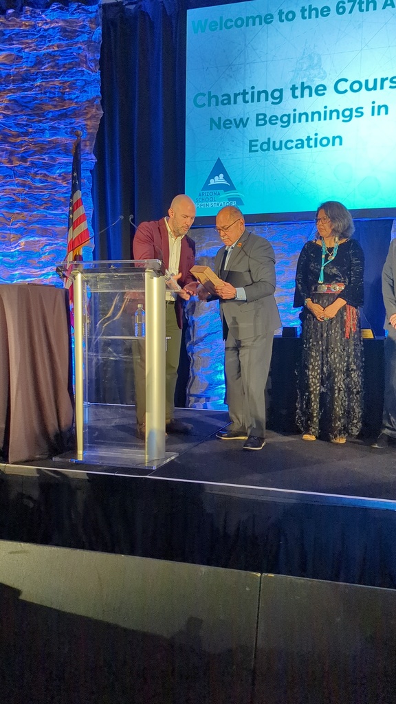 Governing board member receiving an award at a podium and on stage