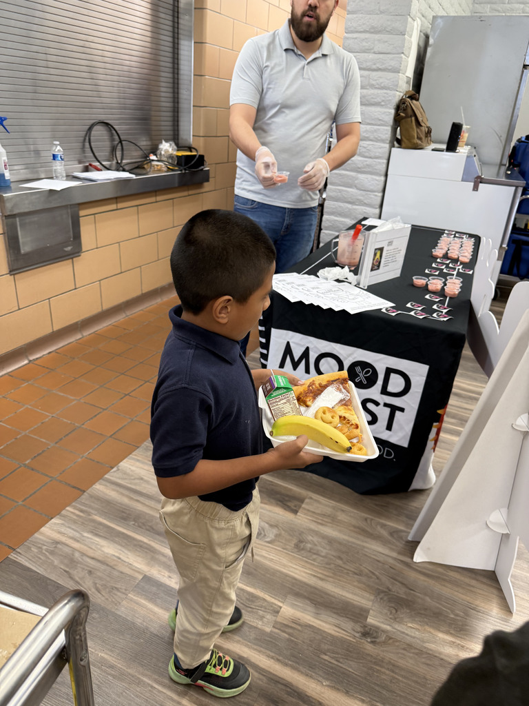 Young boy with tray in hand receiving a smoothie.