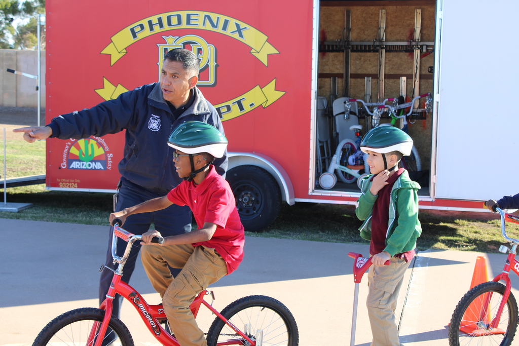 Phoenix Fire Department showing students the way as they ride a bike. 