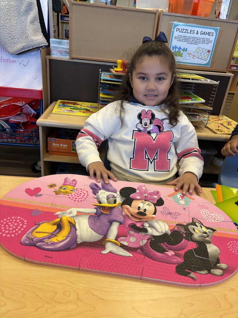 Girl posing with completed Minnie Mouse puzzle