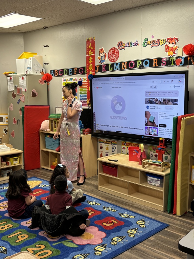 Teacher dressed in traditional Chinese dress giving lesson during circle time