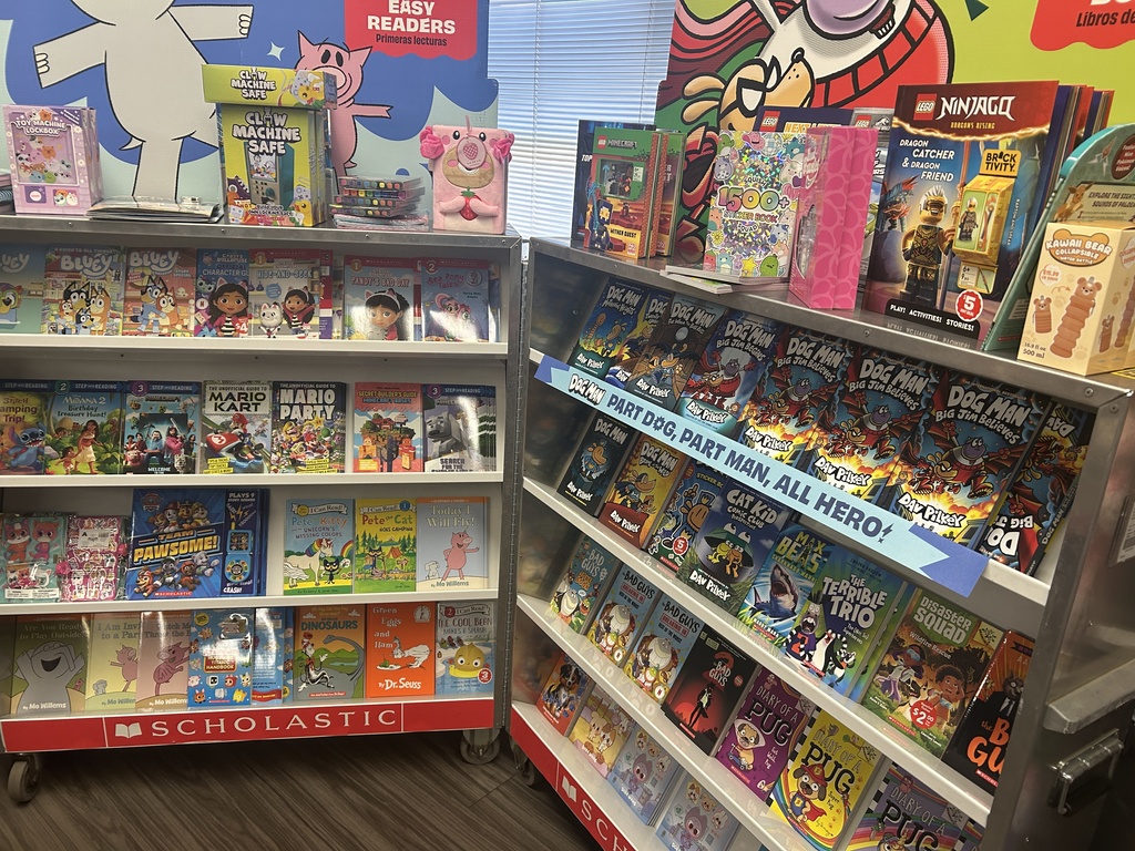 A "Chapter Books" and "Easy Readers" section. A large display of Dav Pilkey’s Dog Man series is prominent. Other visible titles include The Bad Guys, Diary of a Pug, and Narwhal and Jelly.