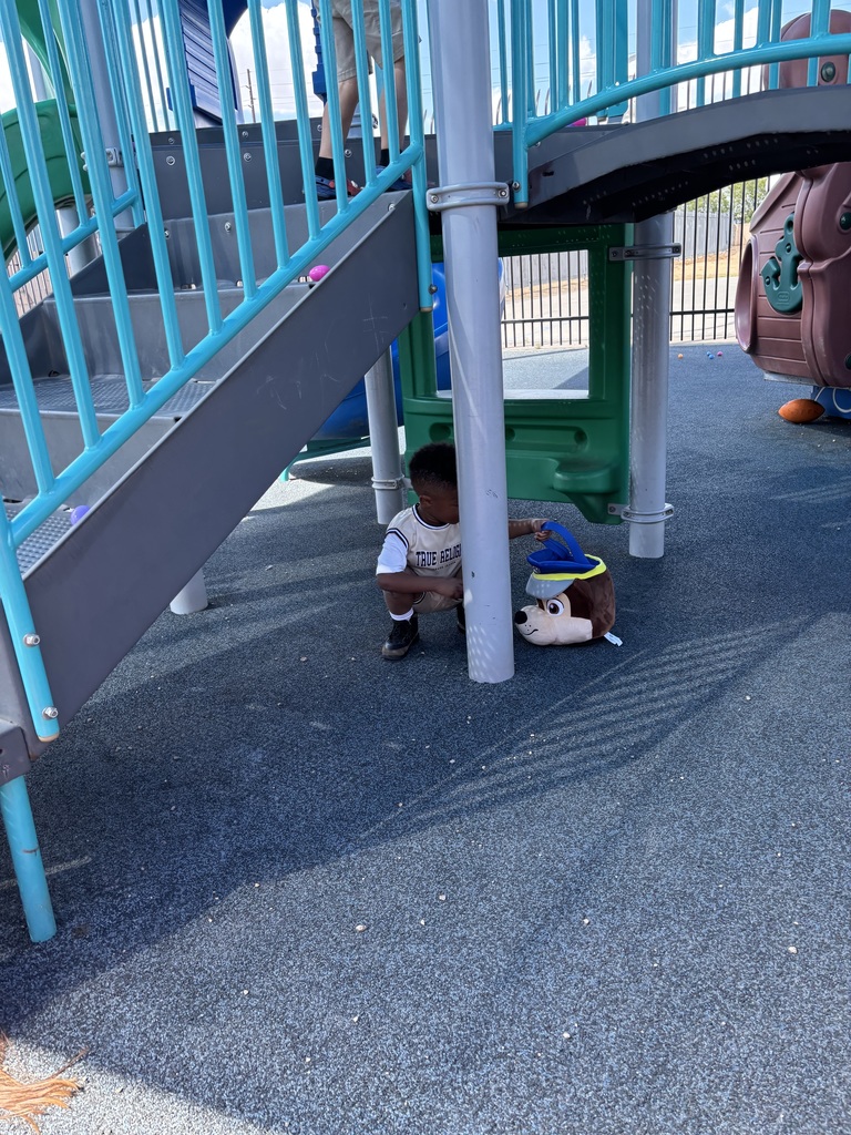 Boy picking up Easter egg on playground