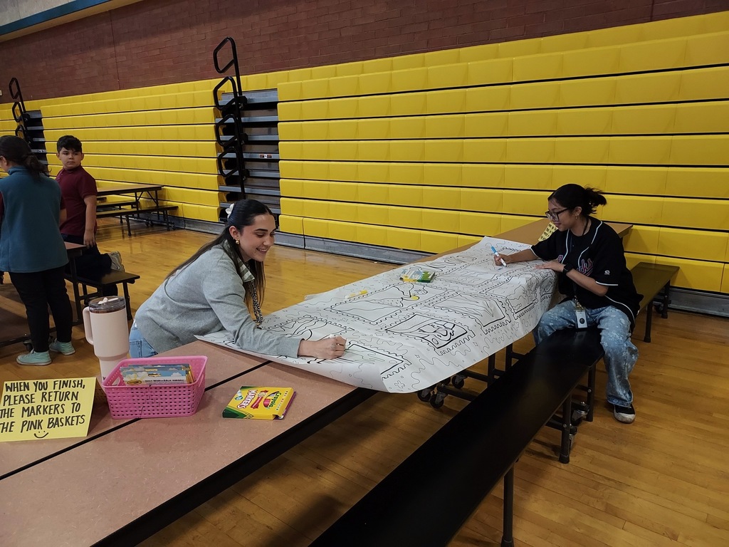 People coloring on a large coloring page