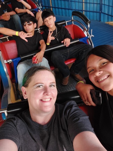Students and a teacher riding a rollercoaster 