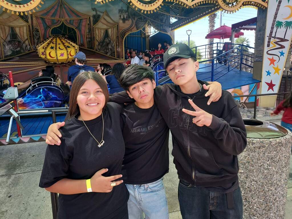 Three students standing outside of a ride at Castles and Coasters