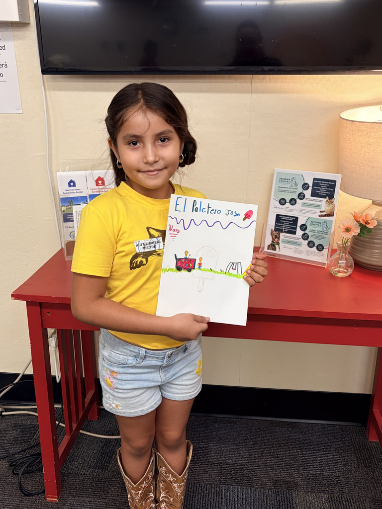 Student holding up picture she drew at Alta E Butler