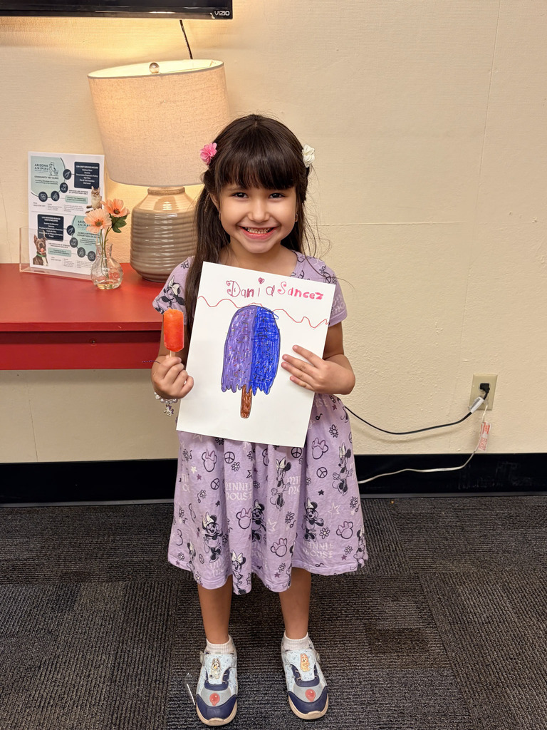Student holding up picture she drew at Alta E Butler