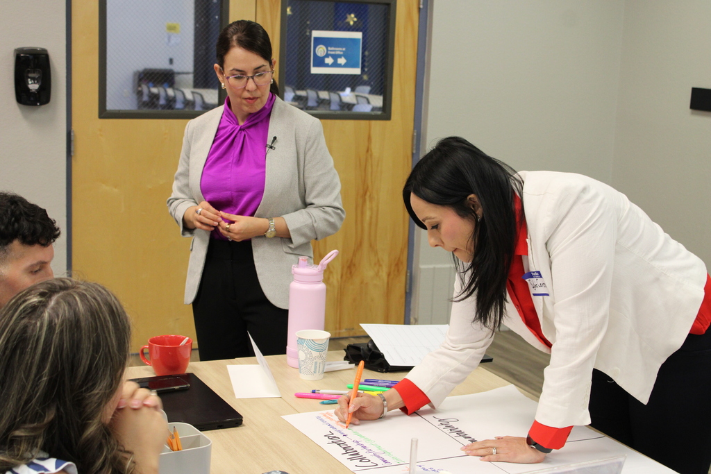 Dr. Lily watching  Sylvia Carrizoza doing a writing exercise 
