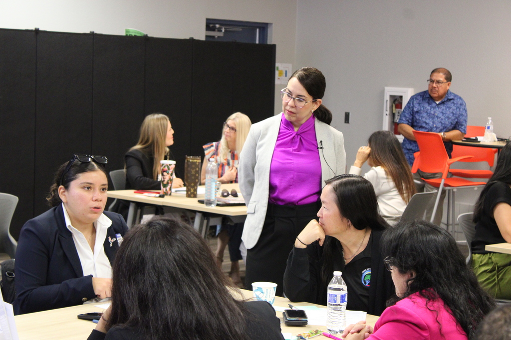 Dr. Lily watching and staff paying attention to Principal Jessica Montelongo