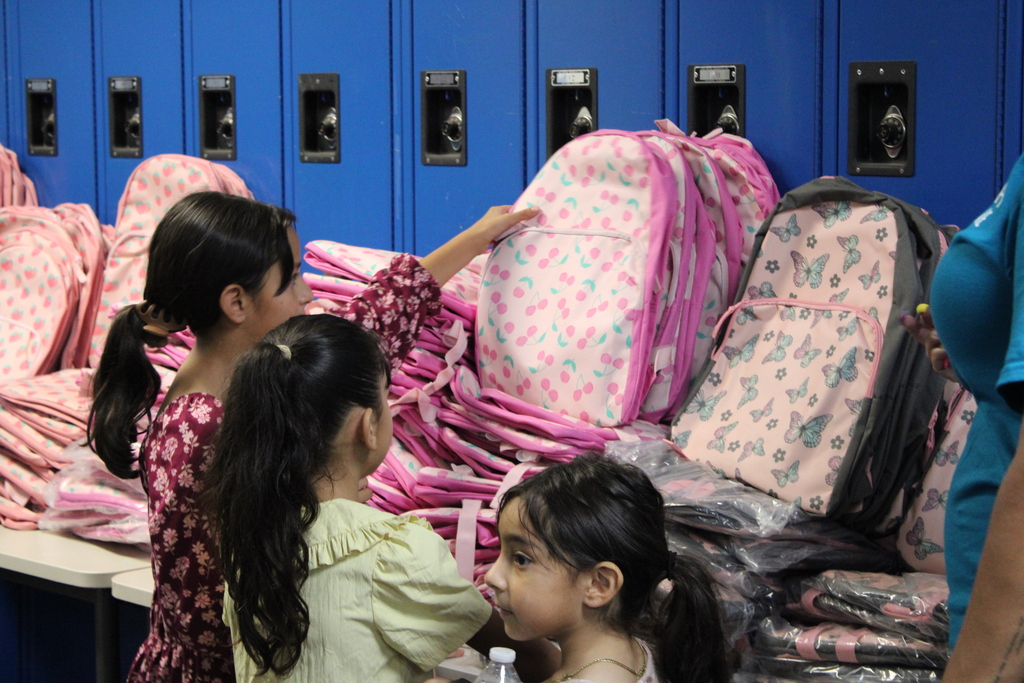 Students picking out backpacks at the Back to School Fair