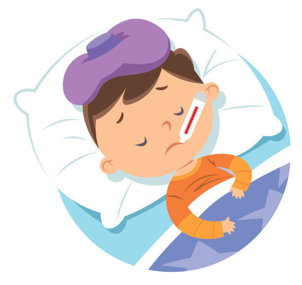Boy in orange pajamas sick in bed with a thermometer in his mouth and ice pack on his head