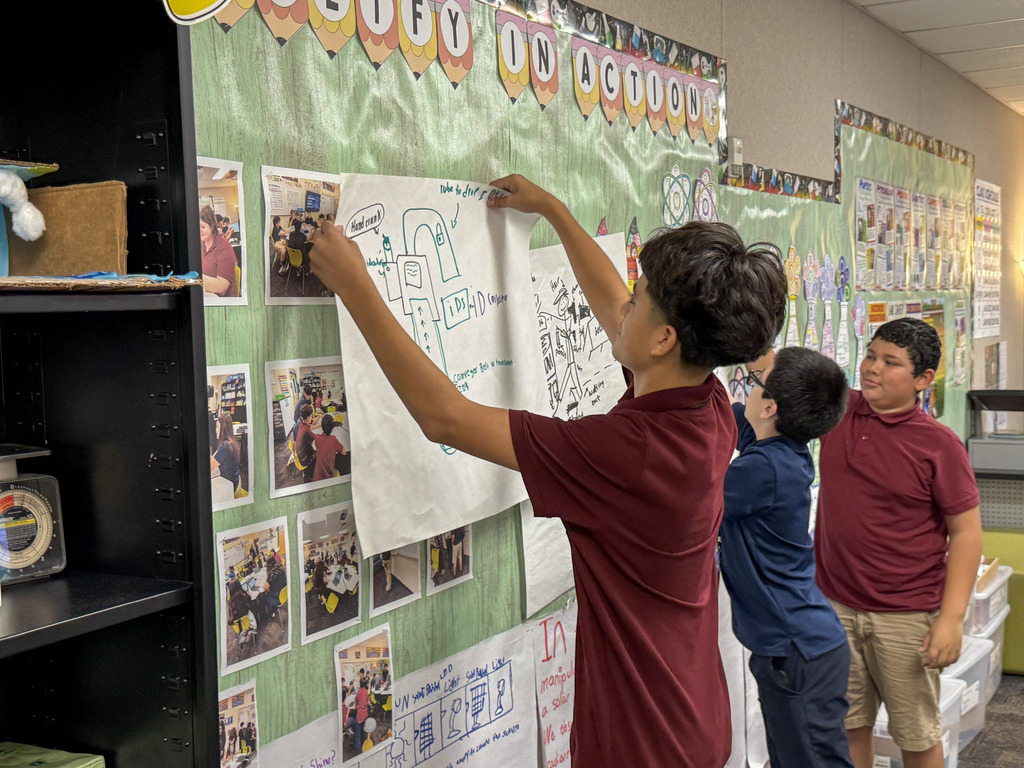 Students in Ms. Magallanes putting up posters