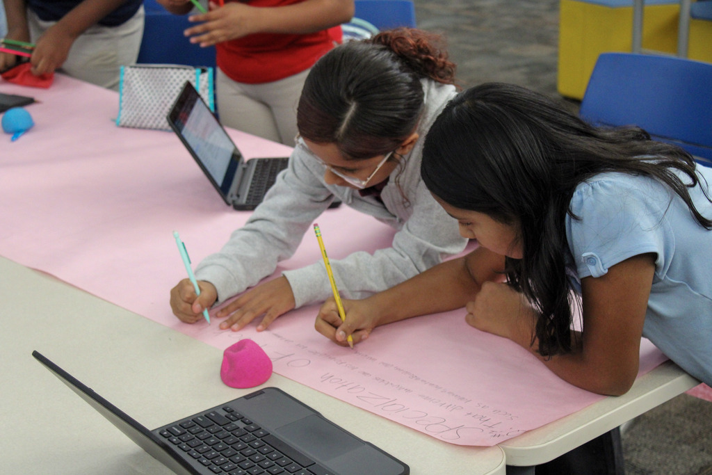 Students in Mr. Bennett's Class doing work on a pink poster