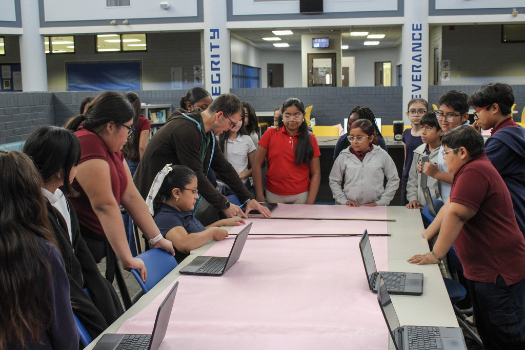 Students in Mr. Bennett's Class doing work on a pink poster