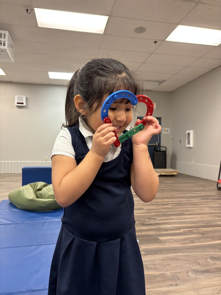 Girl holding up lego heart up to her face