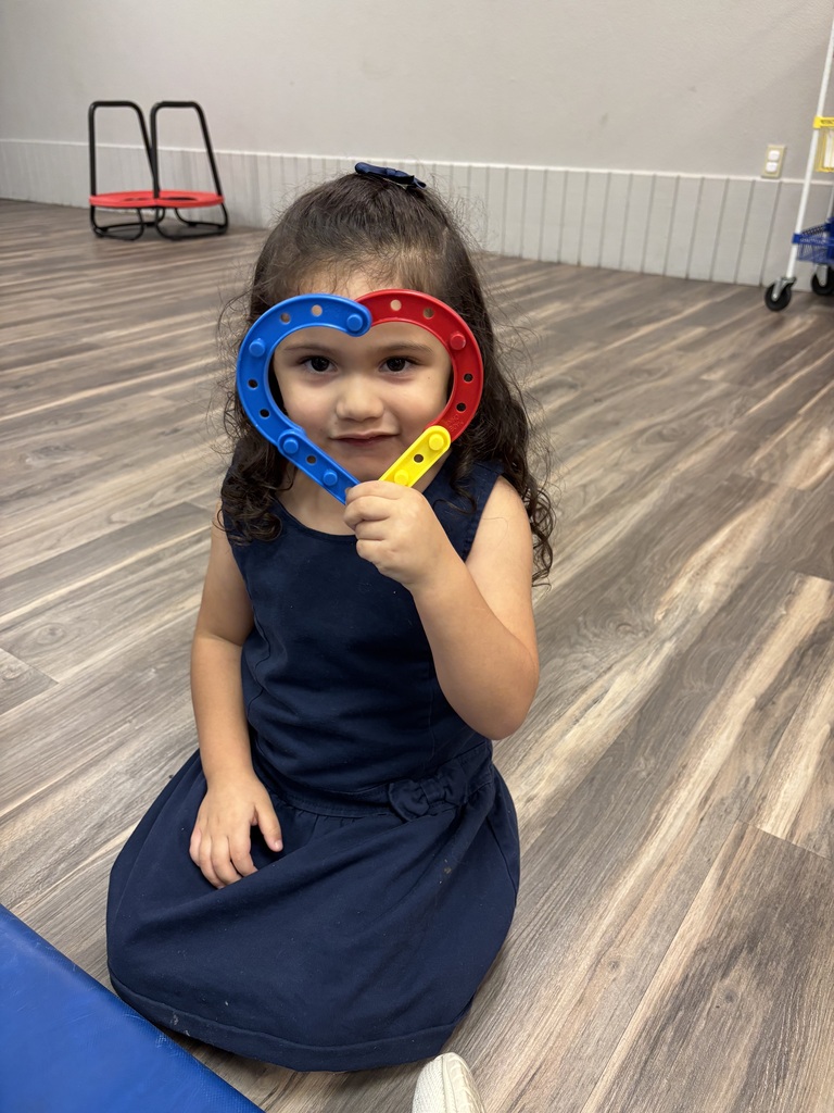 Girl holding up lego heart up to her face
