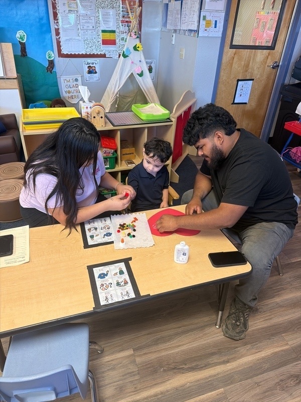 Parents and son doing a project in class
