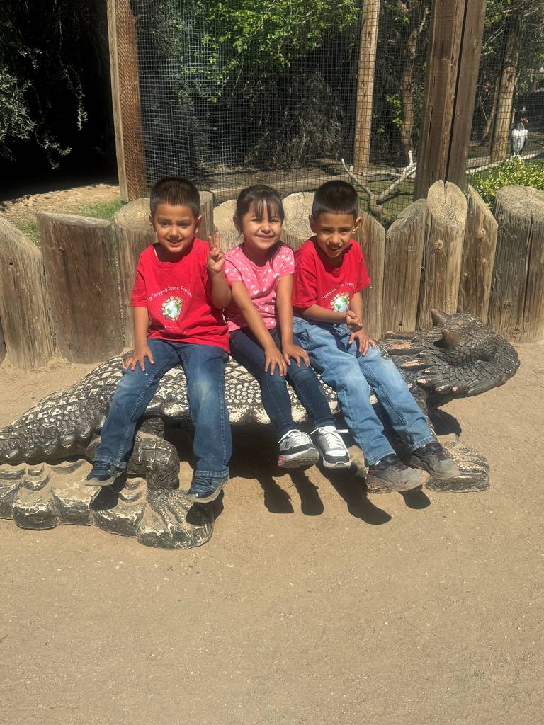 3 students sitting together on a dragon bench