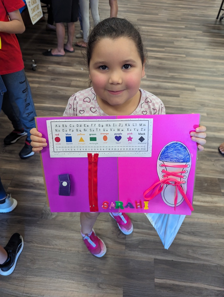 kinder student holding up her artwork