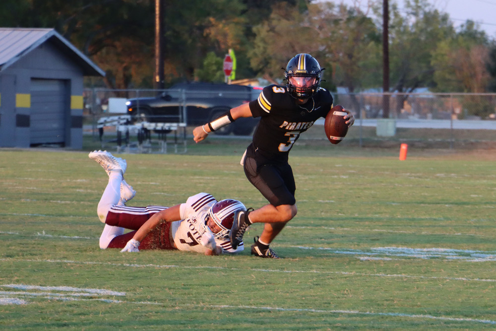 Quarter Back Weston Jackson running the ball past a Poteet defender