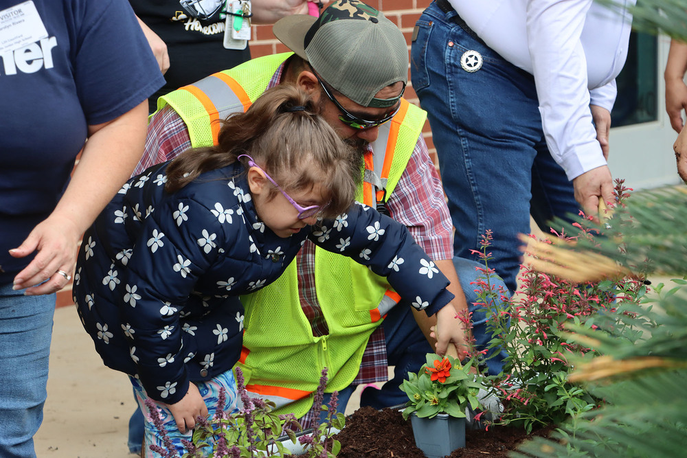 Volunteer with student in garden