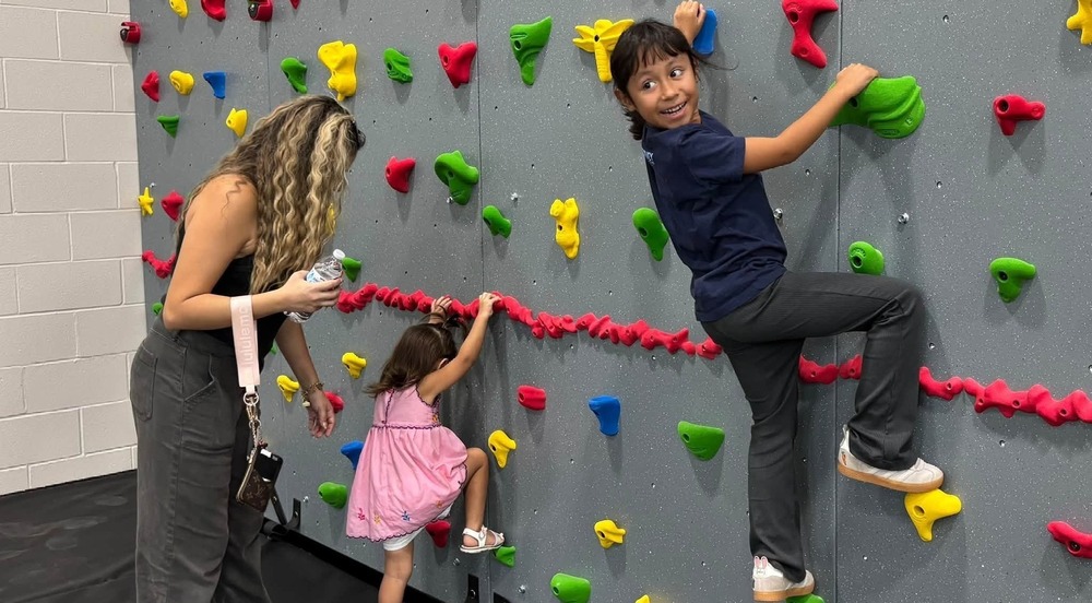 Children use the new climbing wall at the Primary gym