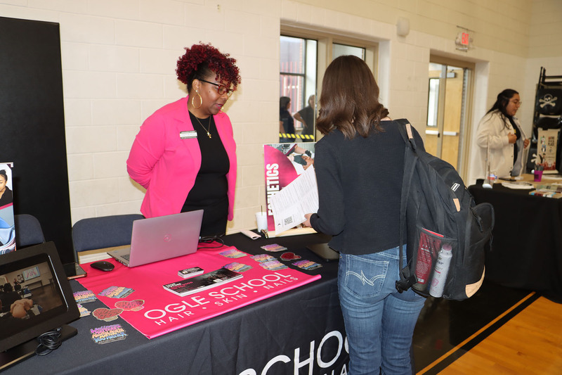 A representative from Ogle talks with a student