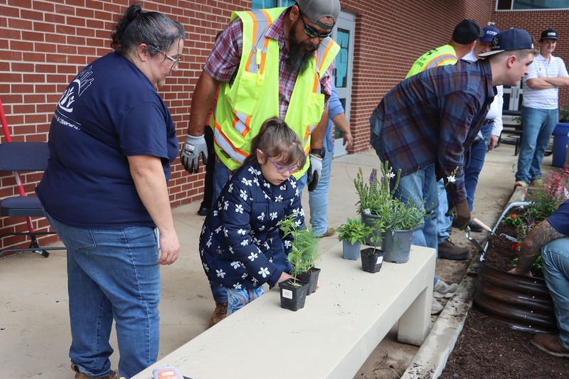 Volunteers with students from the Life Skills class working in the garden