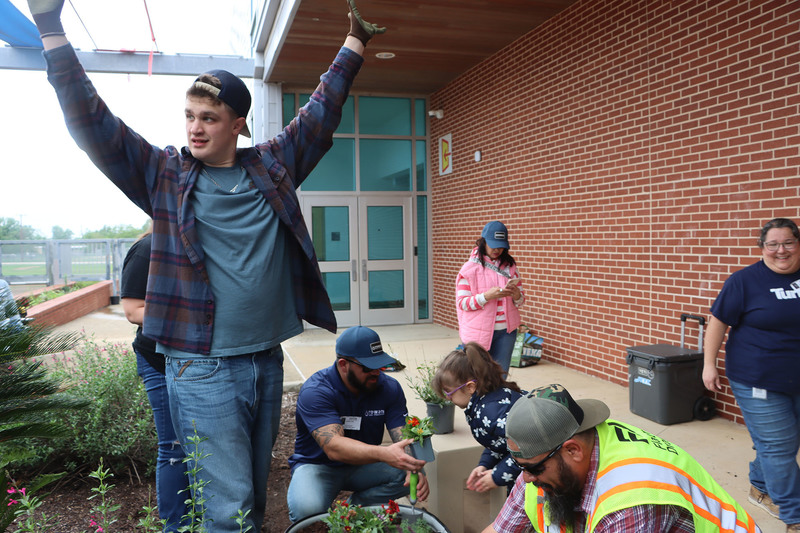 Volunteers with students from the Life Skills class working in the garden