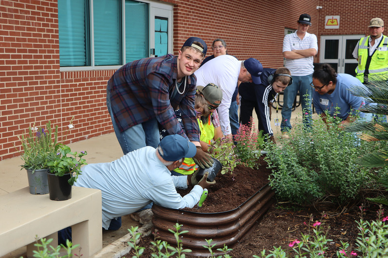 Volunteers with students from the Life Skills class working in the garden