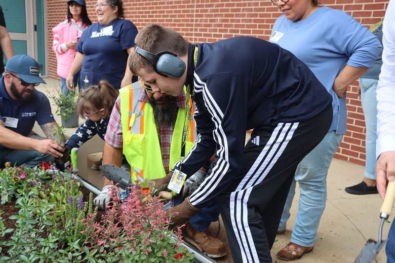 Volunteers with students from the Life Skills class working in the garden