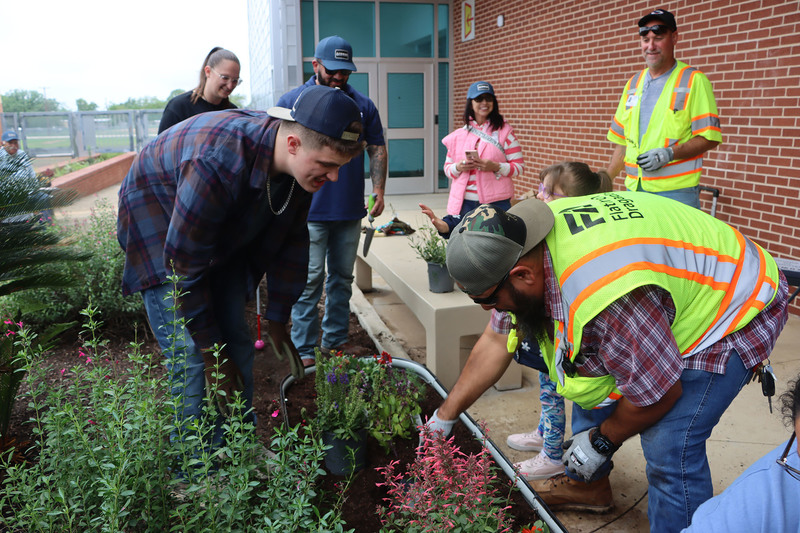 Volunteers with students from the Life Skills class working in the garden