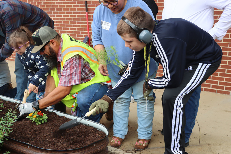 Volunteers with students from the Life Skills class working in the garden