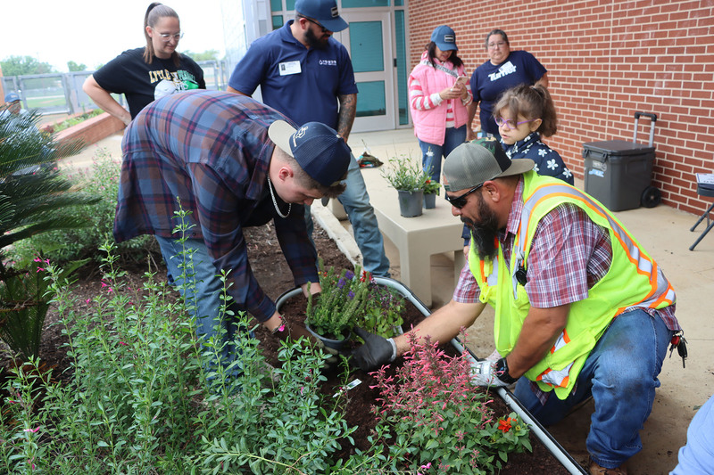 Volunteers with students from the Life Skills class working in the garden