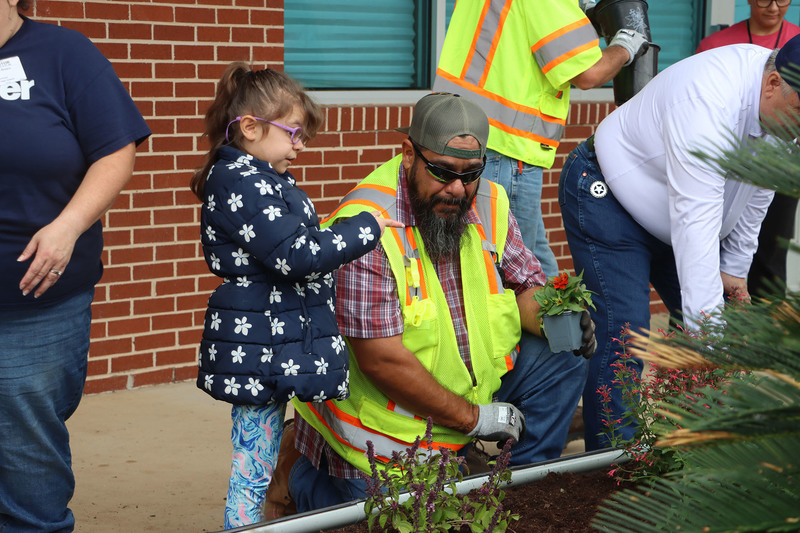 Volunteers with students from the Life Skills class working in the garden