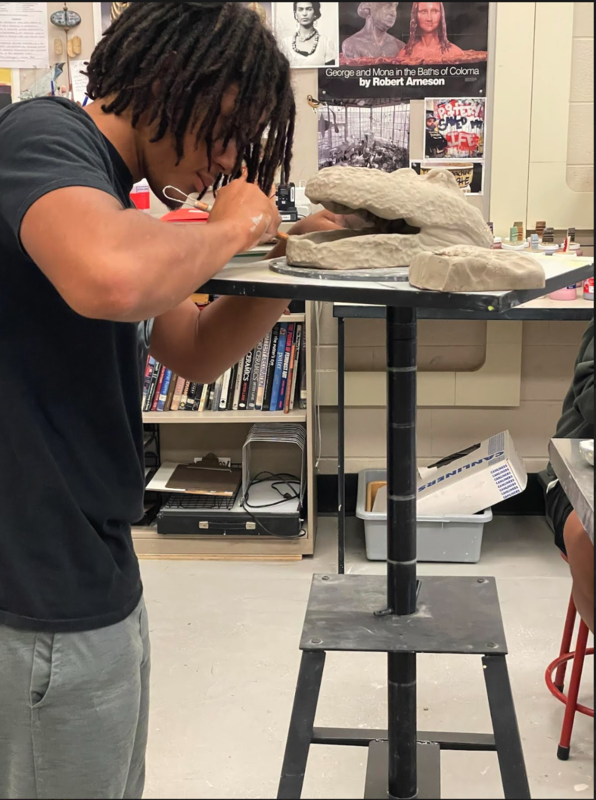 student working on clay art while exploring curiosity