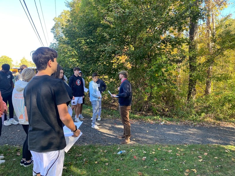 american studies teacher talking to students while they explore curiosity