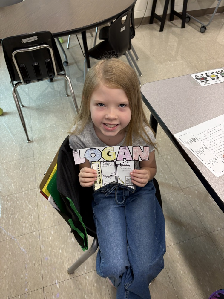 A girl holding up her name.