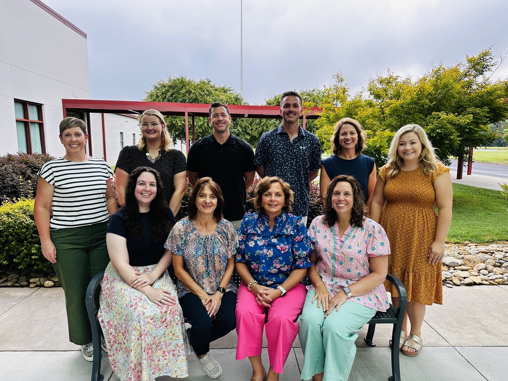 Teachers on and around a bench.