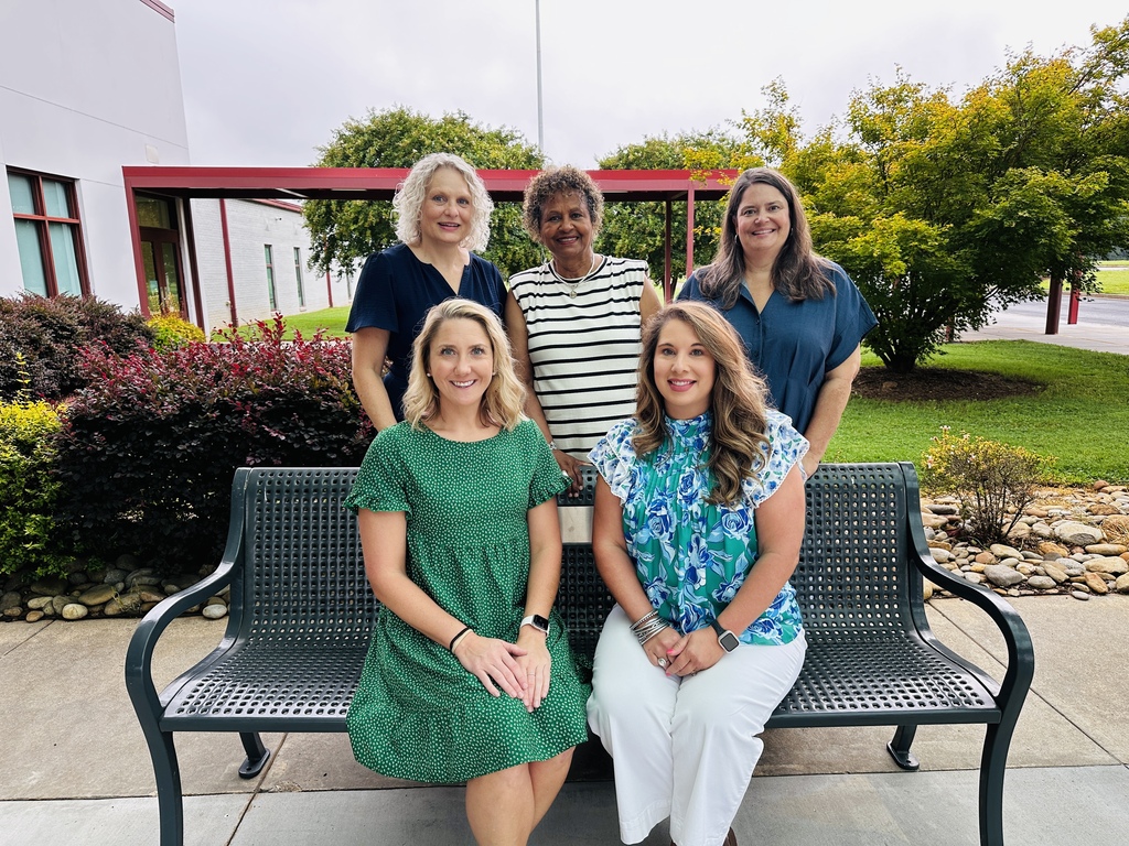 Teachers on and around a bench.