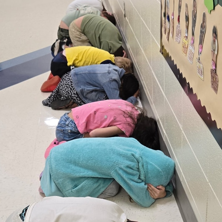 students ducking during a tornado drill