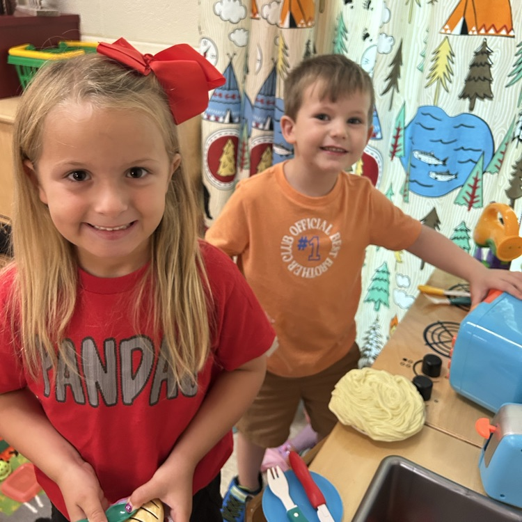 A girl and boy in the kitchen center.