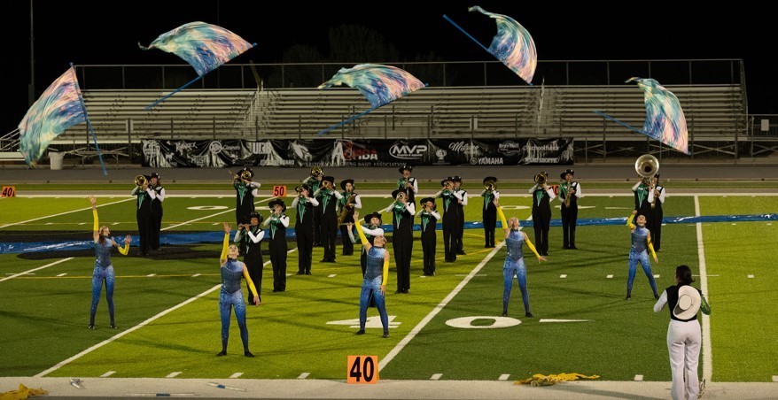 photo of color guard throwing flags in air in front of band
